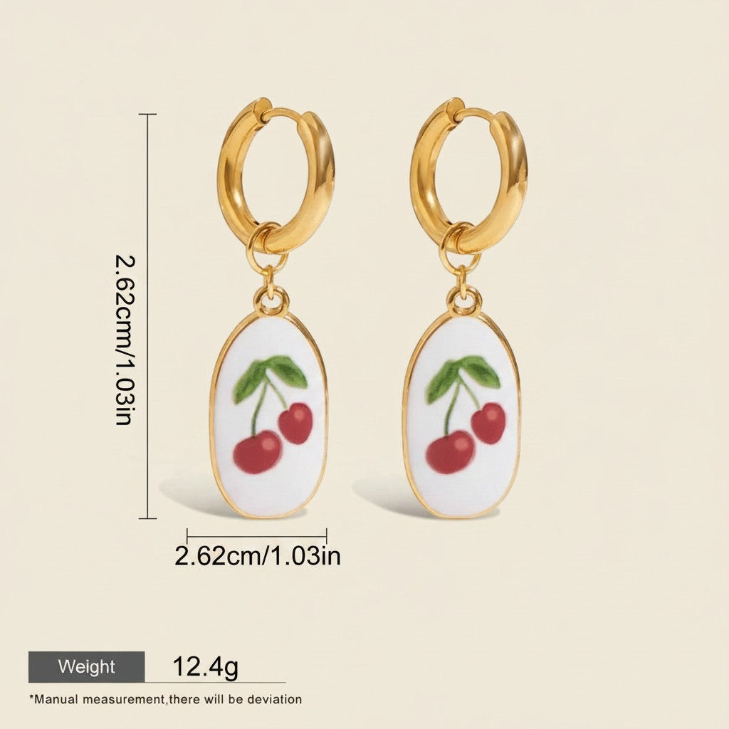 Seraphina Treasures gold hoop earrings with white oval pendants featuring red cherries and green leaves. Waterproof and hypoallergenic.