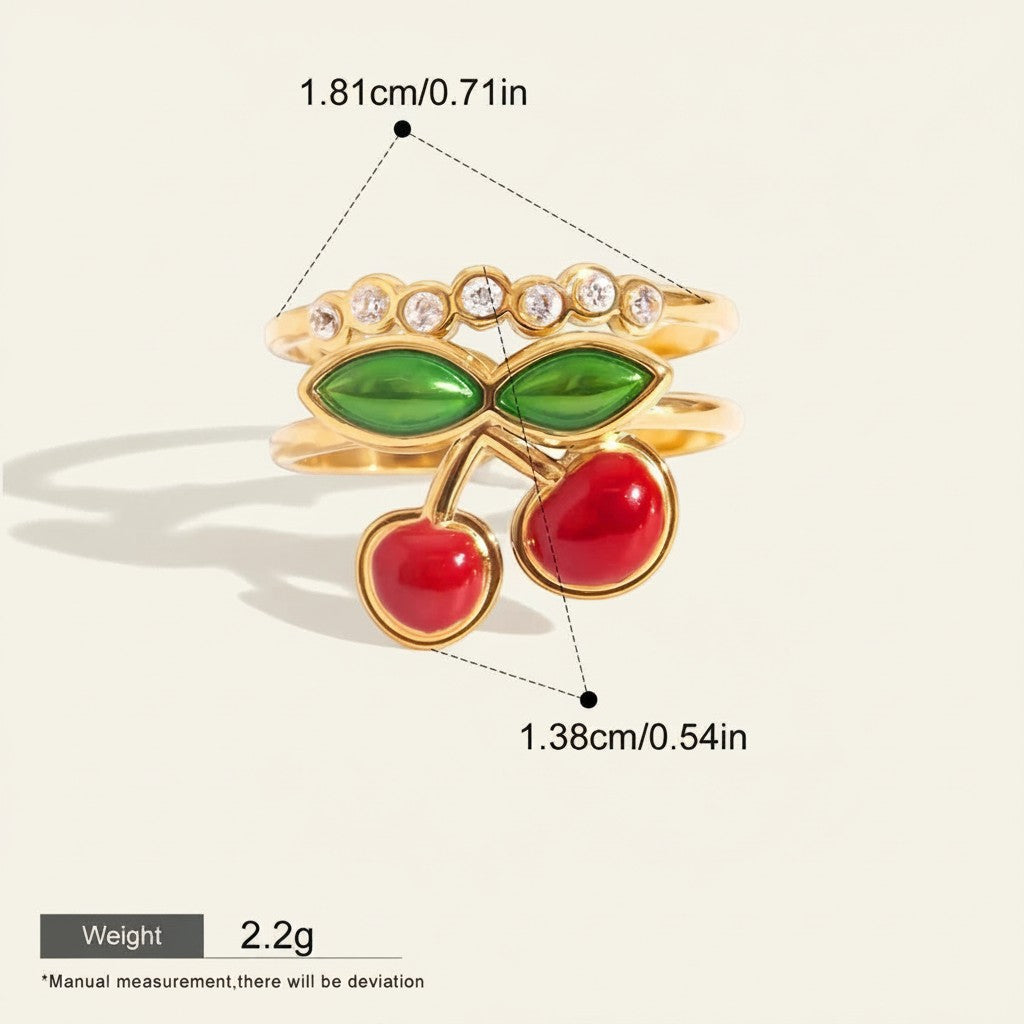 Seraphina Treasures Myrrine gold ring with red cherry charms and green leaves, accented with clear zirconia stones.