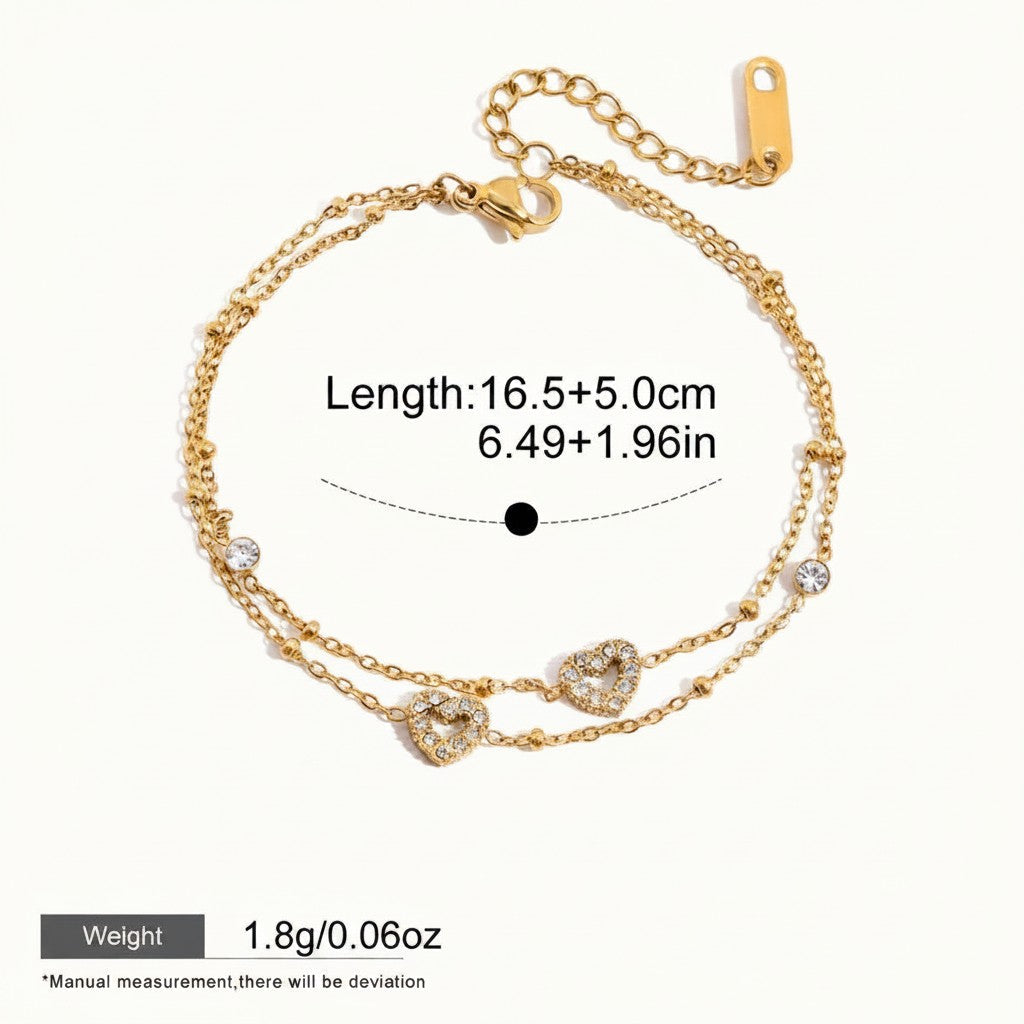 Seraphina Treasures gold-tone two-tier bracelet with cubic zirconia heart charms and small beads. Adjustable chain.