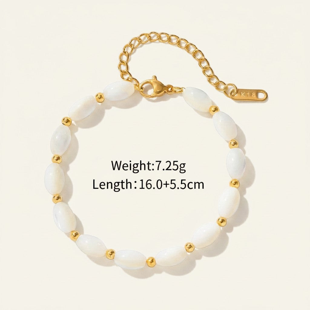 Seraphina Treasures Delia bracelet with oval white shell beads and gold accents, adjustable gold chain.