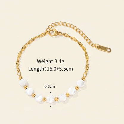 Seraphina Treasures Delia bracelet with white shell beads and gold accents on a gold chain.